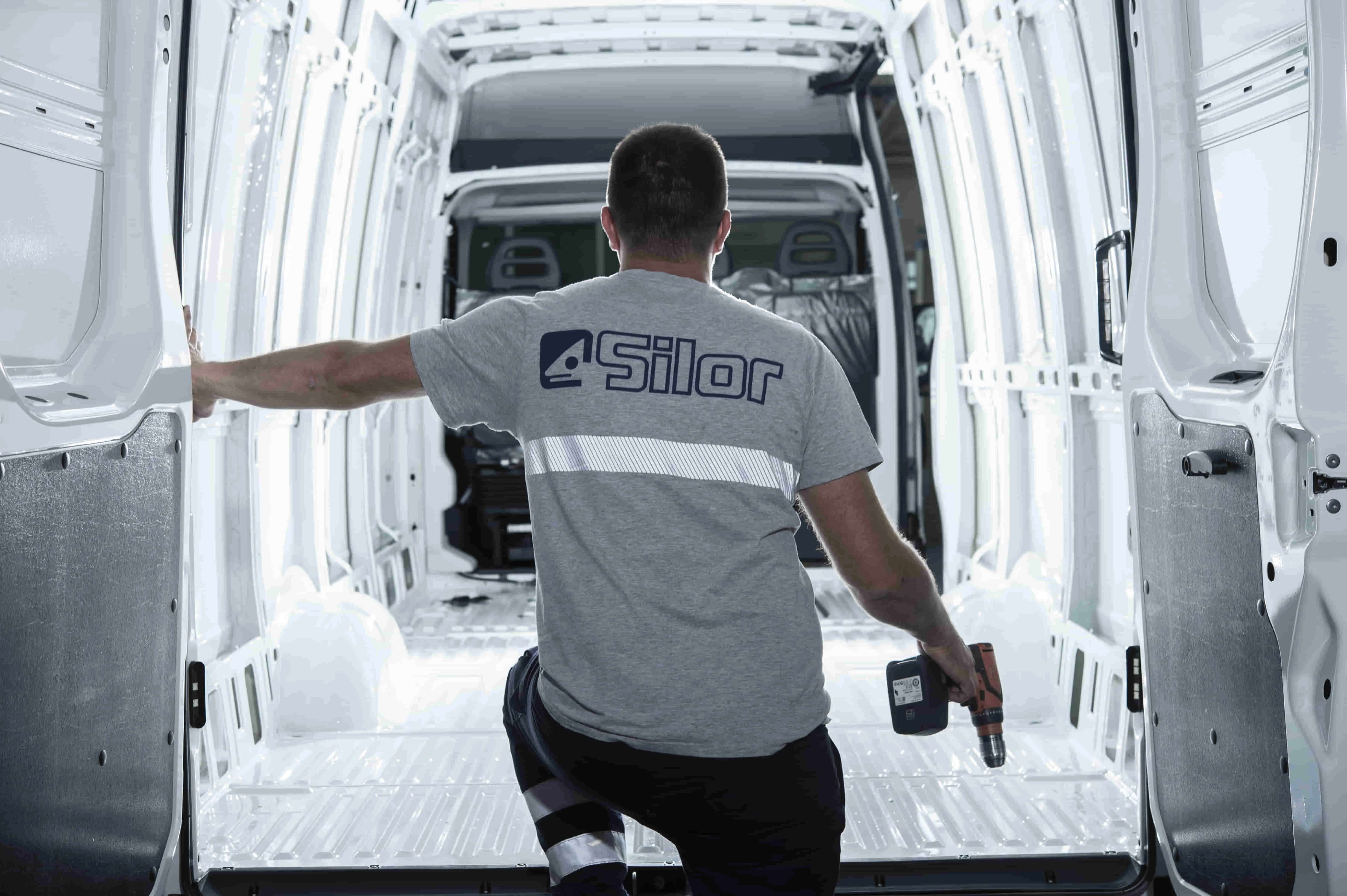 Silor Centro Allestimento Veicoli Commerciali Foto di un collaboratore di Silor che sale su un furgone nel centro allestimenti